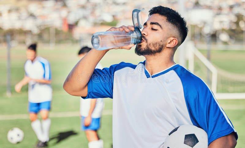 Dois jogadores de futebol masculinos deitado na grama do campo