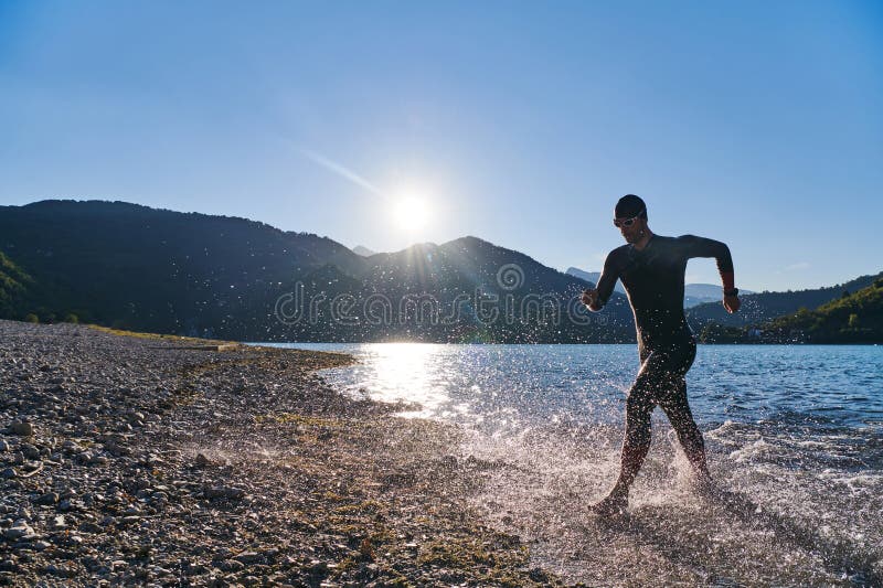 Atleta de triatlón iniciando entrenamiento de natación en el lago imágenes de archivo libres de regalías