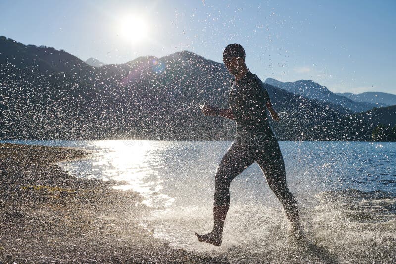 Atleta de triatlón iniciando entrenamiento de natación en el lago fotografía de archivo libre de regalías