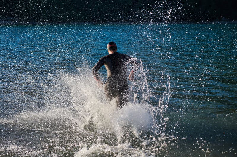 Atleta de triatlón iniciando entrenamiento de natación en el lago fotos de archivo