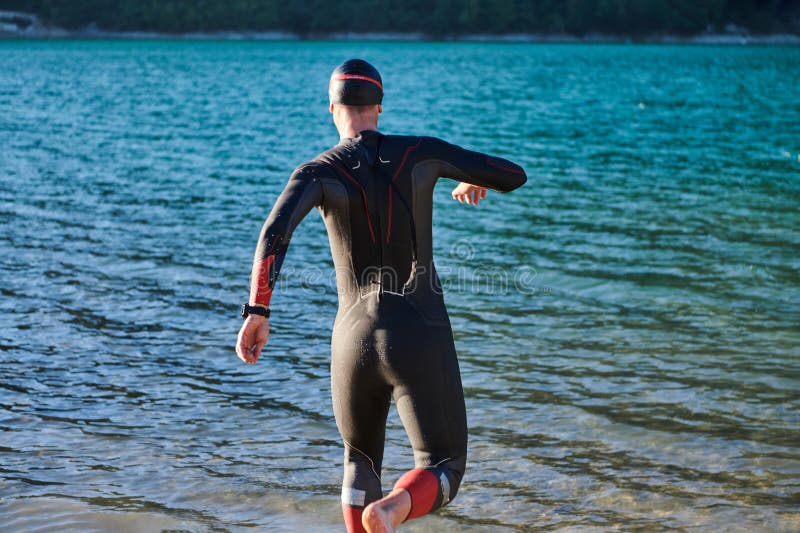 Atleta de triatlón iniciando entrenamiento de natación en el lago imagenes de archivo
