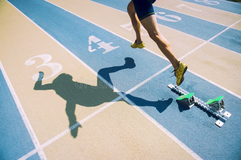 Atleta en zapatos del oro que esprinta a través de línea de salida