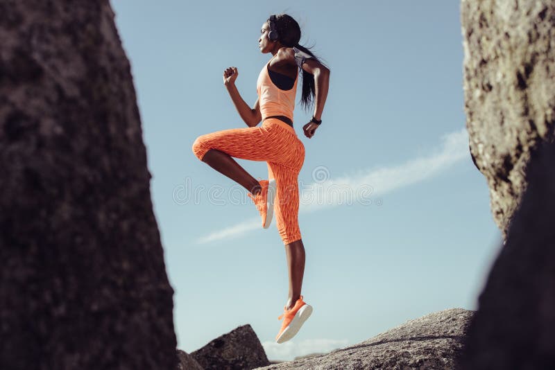 Atleta fêmea africano que salta e que estica