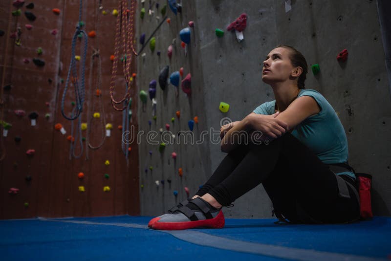Atleta pensativo que olha acima ao relaxar no clube imagens de stock royalty free Atleta pensativo que olha acima ao relaxar no clube imagens de stock royalty free