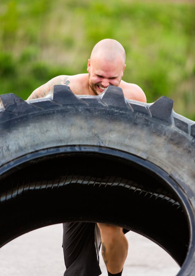 Atleta resuelto Doing Tire-Flip Exercise fotos de archivo Atleta resuelto Doing Tire-Flip Exercise fotos de archivo