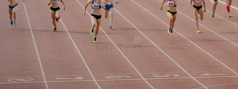 Atletas femeninas del grupo corren carrera de velocidad en pista de estadio imagen de archivo libre de regalías