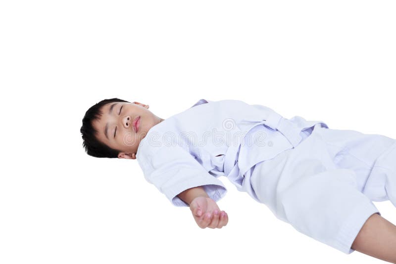 Atleti asiatici il taekwondo del bambino che si riposa incosciente sul pavimento immagini stock Atleti asiatici il taekwondo del bambino che si riposa incosciente sul pavimento immagini stock