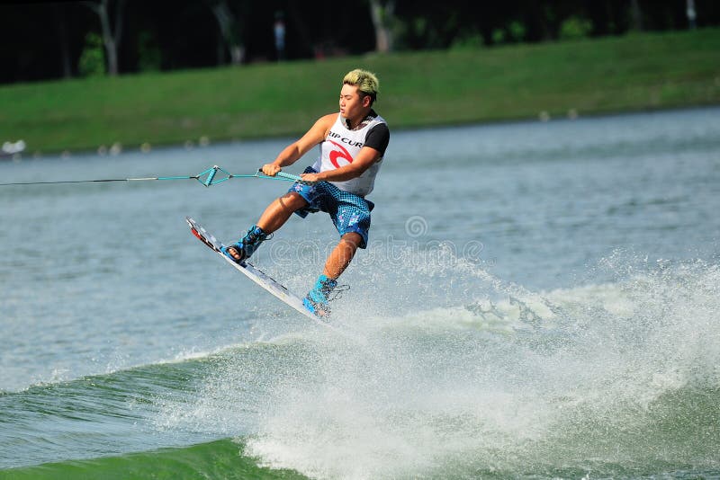 Atlety spełniania wyczyn kaskaderski podczas rip curl Singapur Krajowego Inter uniwerku 2014 & Politechnicznego Wakeboard mistrzo. SINGAPUR, LIPIEC - 20: Atlety spełniania wyczyn kaskaderski podczas rip curl Singapur Krajowego Inter uniwerku & Politechniczny Wakeboard mistrzostwo 2014 na Lipu 20, 2014 w Singapur