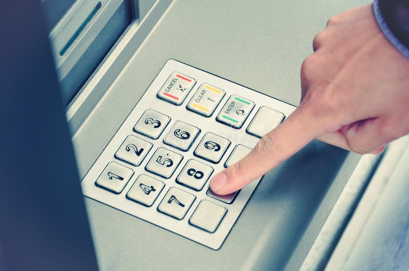 Hand entering personal identification number on ATM dial panel. Hand entering personal identification number on ATM dial panel