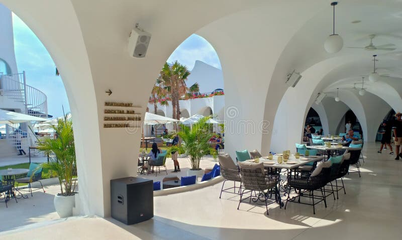 Kuta, Indonesia - 15th October 2019; The atmosphere of the quiet restaurant on sunny day in the afternoon. Outdoors, tourists have a good time and relax under white umbrellas in the Cafe Del Mar Bali beach club. Whole building are white painted. Kuta, Indonesia - 15th October 2019; The atmosphere of the quiet restaurant on sunny day in the afternoon. Outdoors, tourists have a good time and relax under white umbrellas in the Cafe Del Mar Bali beach club. Whole building are white painted