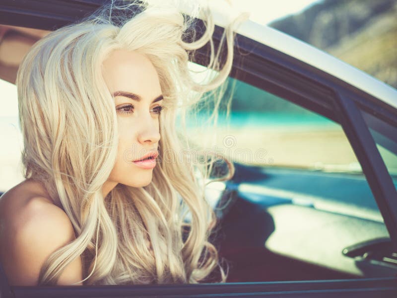 Atmospheric portrait of beautiful blonde in car