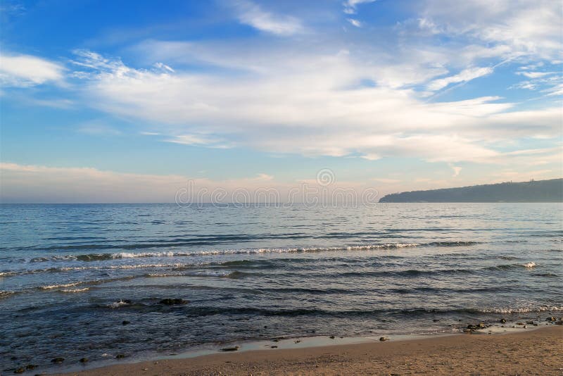 Atmospheric seascape. Blue sky with white clouds over the calm winter sea in a light evening haze, soft focus stock images Atmospheric seascape. Blue sky with white clouds over the calm winter sea in a light evening haze, soft focus stock images