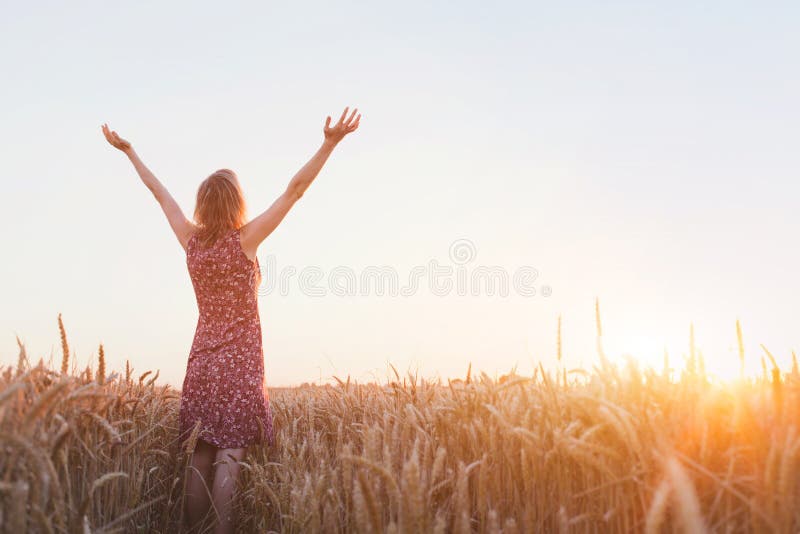 Breathing, woman with raised hands enjoying sunset in the field. Breathing, woman with raised hands enjoying sunset in the field