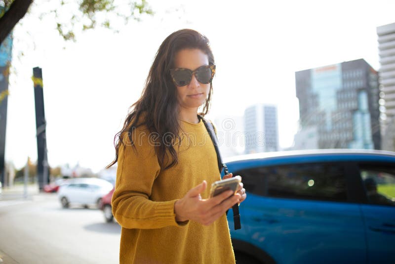 Atractiva mujer asiática caminando fuera de la ciudad usando el teléfono móvil foto de archivo