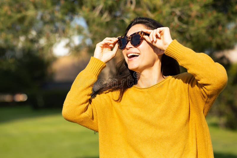 Atractiva mujer asiática con gafas de sol sonriendo afuera imagenes de archivo