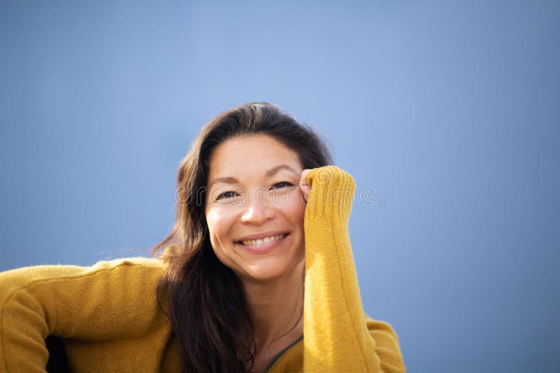 Atractiva mujer asiática sentada afuera y sonriendo fotografía de archivo libre de regalías