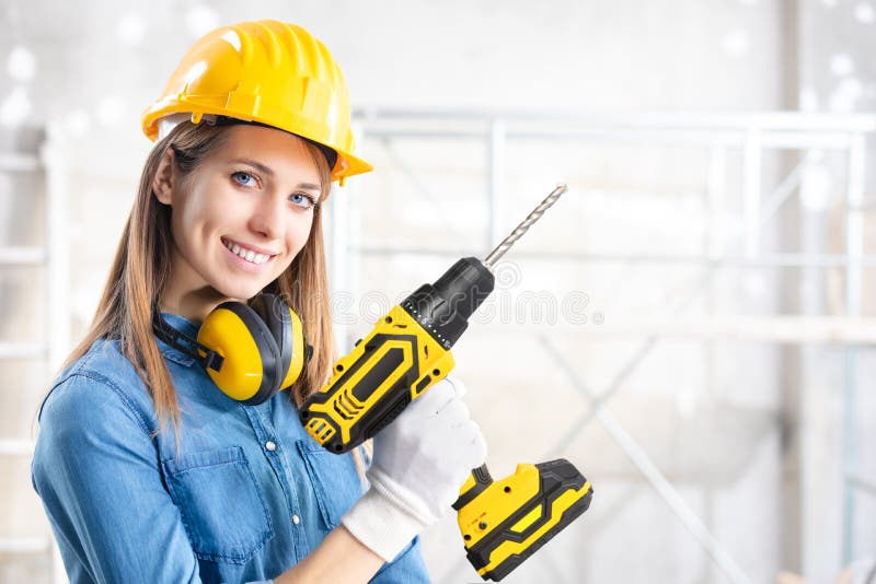 Atractiva mujer constructor con un taladro de mano foto de archivo