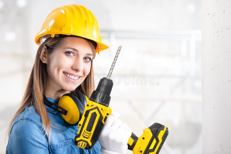 Atractiva mujer constructor con un taladro de mano imagen de archivo libre de regalías