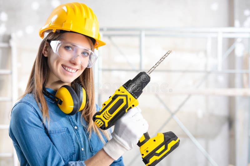 Atractiva mujer constructor con un taladro de mano fotografía de archivo libre de regalías