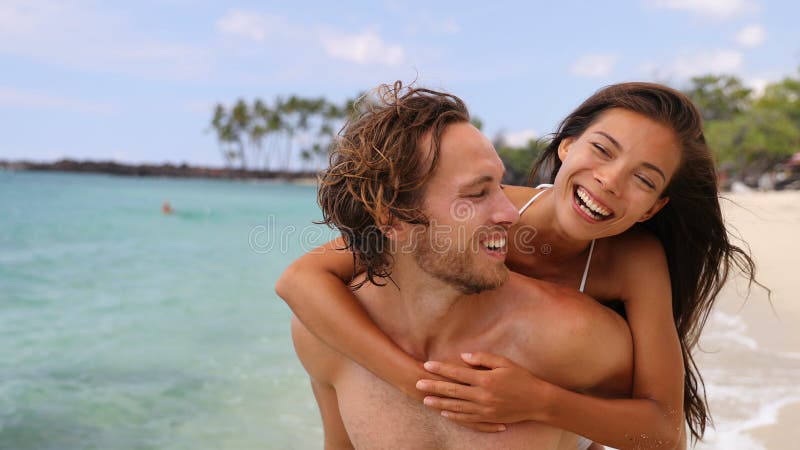 Atractiva pareja feliz riéndose divirtiéndose en la playa metrajes