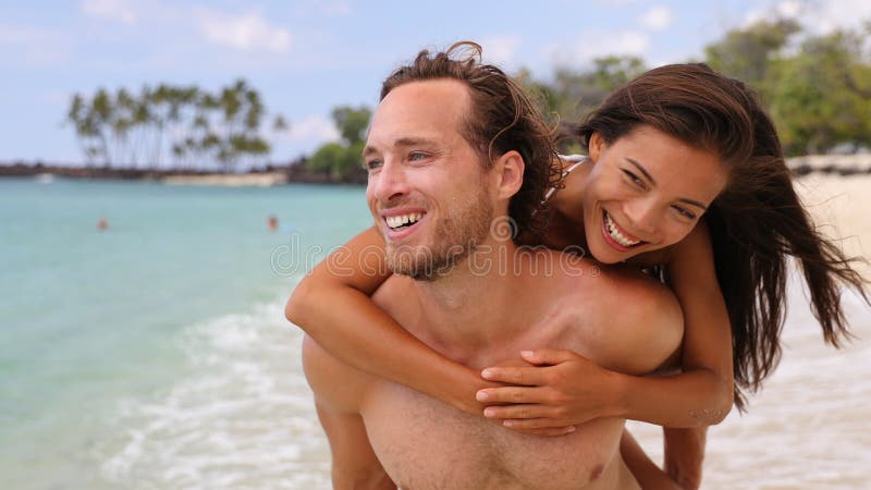Atractiva pareja feliz riéndose divirtiéndose en la playa metrajes