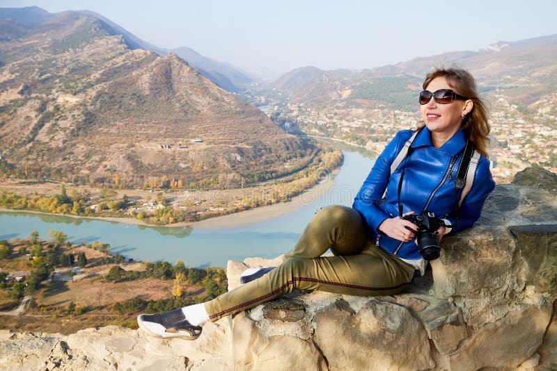 Atractiva y hermosa joven que es mujer viajera fotógrafa sosteniendo una moderna cámara espejo en las manos al aire libre imagenes de archivo