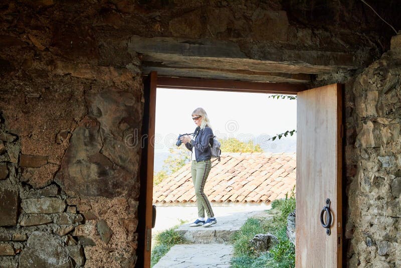 Atractiva y hermosa joven que es mujer viajera fotógrafa sosteniendo una moderna cámara espejo en las manos al aire libre fotos de archivo