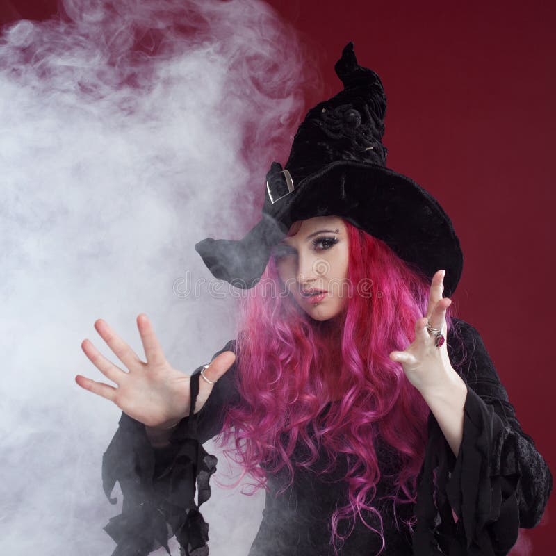 Atrakcyjna kobieta w czarownicach kapelusz i kostium z czerwonym włosy halloween