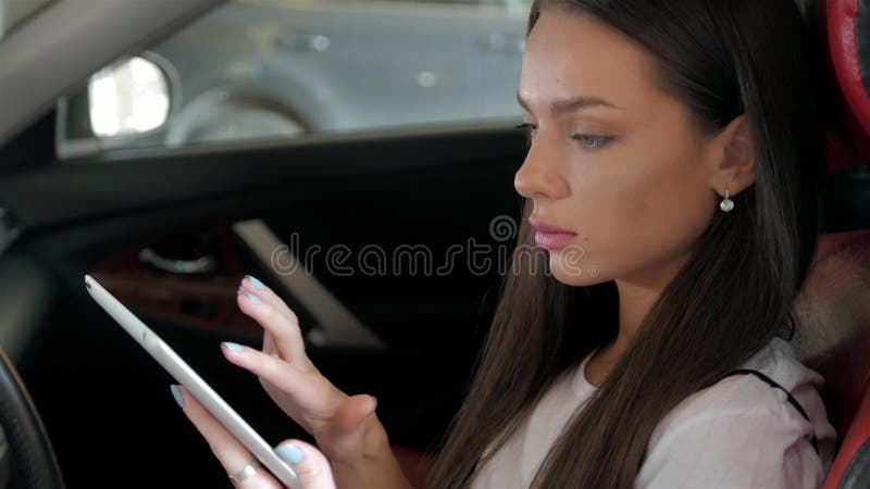 Atrakcyjnej wykonawczej żeńskiej kierownik pracy dotyka pastylki luksusowy samochodowy komputer zdjęcia stock Atrakcyjnej wykonawczej żeńskiej kierownik pracy dotyka pastylki luksusowy samochodowy komputer zdjęcia stock
