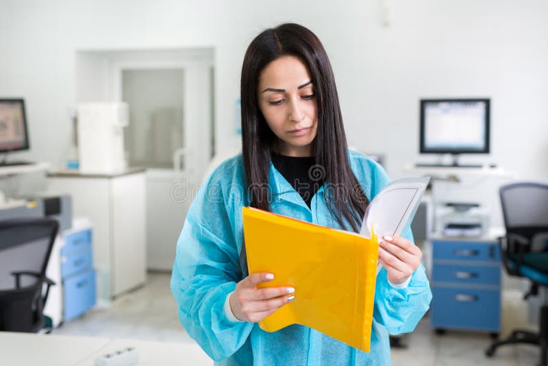 Atrakcyjny ?e?ski lab pracownik robi badania medyczne w nowo?ytnym laboratorium Naukowa mienie dokumentuje falc?wk? z obrazy royalty free Atrakcyjny ?e?ski lab pracownik robi badania medyczne w nowo?ytnym laboratorium Naukowa mienie dokumentuje falc?wk? z obrazy royalty free