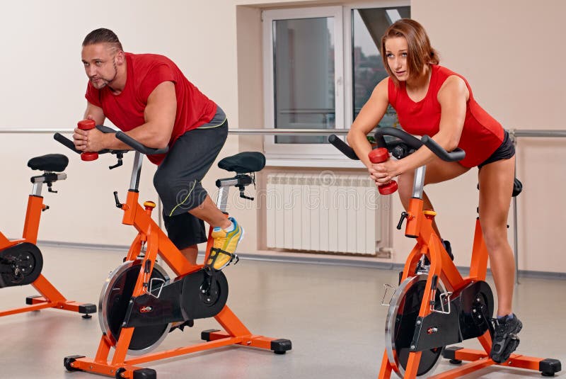 Atrakcyjny pary bycicle kolarstwo w gym zdjęcie stock Atrakcyjny pary bycicle kolarstwo w gym zdjęcie stock