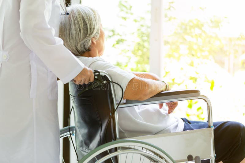 Att bry sig stöttande handikappade personer för doktor eller för sjuksköterska, alzheimer hög asiatisk kvinna på rullstolen, kvin fotografering för bildbyråer