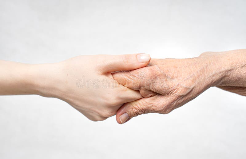 Att hjälpa till att hantera begreppet äldre genom att hålla hand i gamla hand. fotografering för bildbyråer