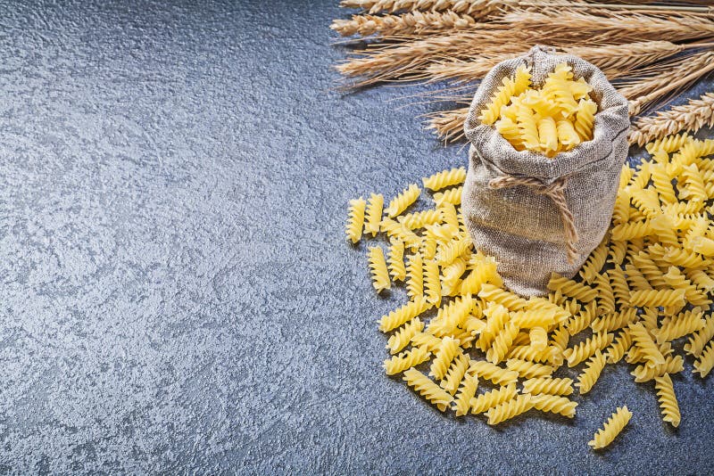 Att hänga löst råg för vete för pasta för säckgenvägspiralen guld- gå i ax på bla arkivbild Att hänga löst råg för vete för pasta för säckgenvägspiralen guld- gå i ax på bla arkivbild