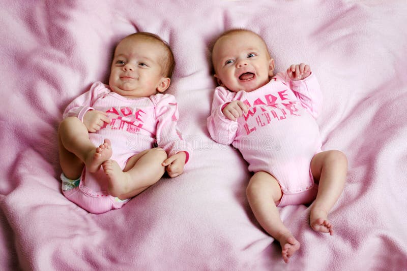 Some cute fraternal twins on a pink blanket. Some cute fraternal twins on a pink blanket