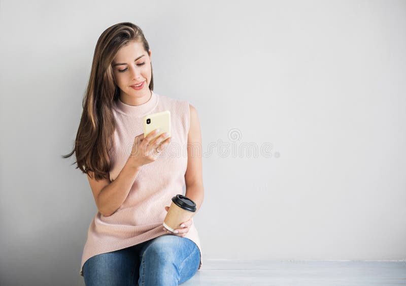 Att le kvinna med hjälp av smart telefon Arbetskvinna skriver på mobiltelefon och dricker kaffe Kopiera utrymme Studio-skott royaltyfri bild Att le kvinna med hjälp av smart telefon Arbetskvinna skriver på mobiltelefon och dricker kaffe Kopiera utrymme Studio-skott royaltyfri bild