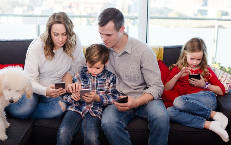 Att le uppfostrar med barn som spenderar tid som spelar med smartph arkivbild Att le uppfostrar med barn som spenderar tid som spelar med smartph arkivbild
