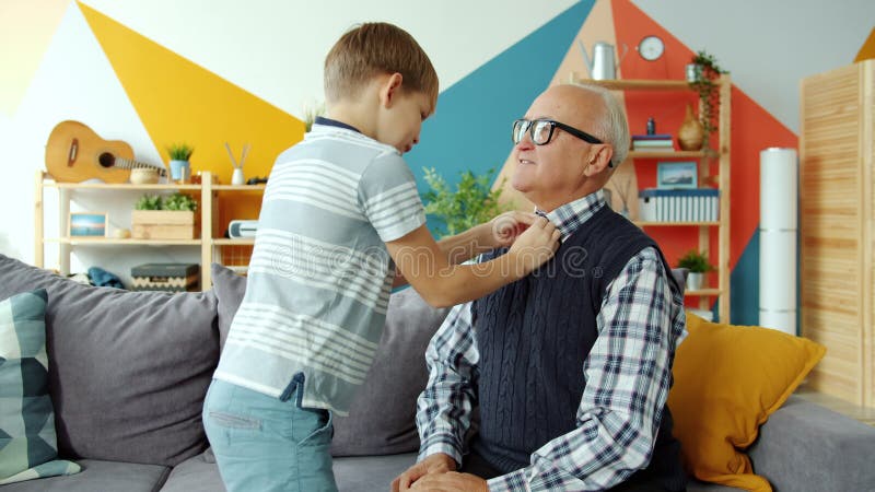Att ta hand om en liten pojke som hjälper en gammal man med kläder och sedan ha kul inomhus hemma lager videofilmer