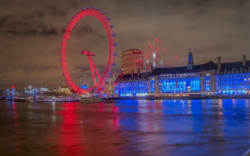 Att tycka om en älskvärd sikt av det London ögat tände med färgrika ljus på natten från den westminster bron arkivbilder Att tycka om en älskvärd sikt av det London ögat tände med färgrika ljus på natten från den westminster bron arkivbilder