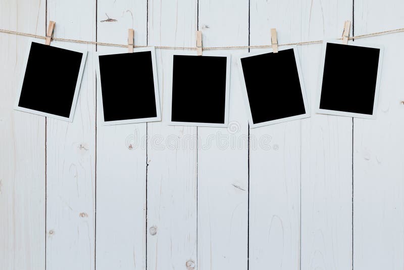 Attaccatura in bianco della struttura di cinque foto sul fondo del bordo di legno fotografia stock Attaccatura in bianco della struttura di cinque foto sul fondo del bordo di legno fotografia stock