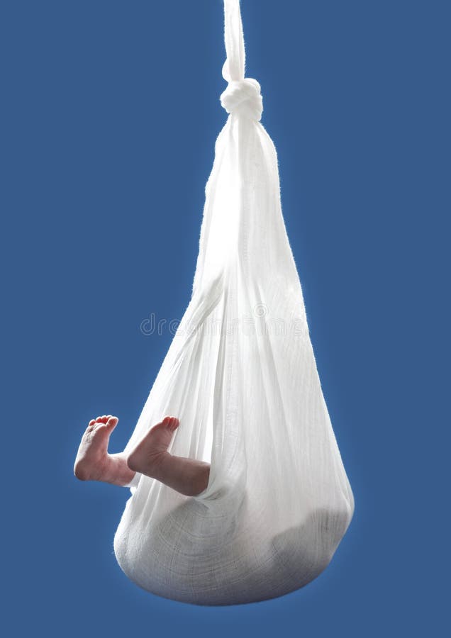 Newborn child hanging from cloth over blue background. Newborn child hanging from cloth over blue background