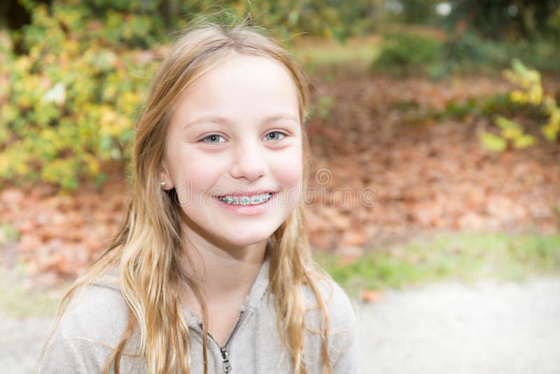 Attache l'ado mignon de sourire extérieur de beauté de fille d'adolescent de dents photographie stock libre de droits Attache l'ado mignon de sourire extérieur de beauté de fille d'adolescent de dents photographie stock libre de droits