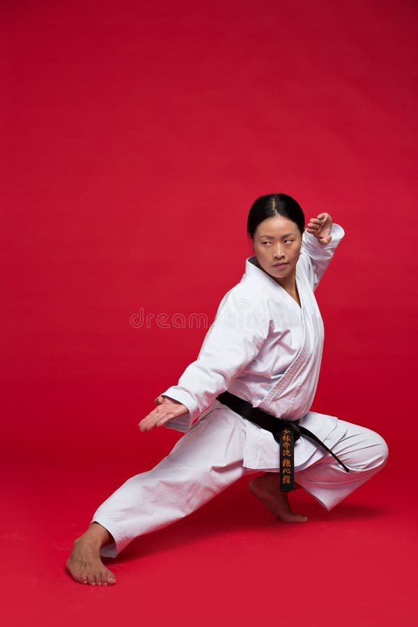 Petite Fille Dans Le Karaté Costume Kimono En Studio À Fond Noir. Enfant  Femme Montre Judo Ou Karaté Stans En Uniforme Blanc Avec Ceinture Jaune.  Art Martial Sport Individuel Pour Les Enfants.