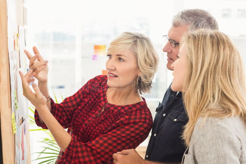 Attentive business team looking at notes on the wall stock image Attentive business team looking at notes on the wall stock image