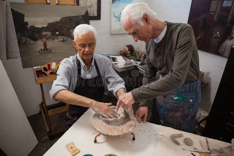 Senior Man Assisting in Making Pottery during Drawing Class Stock Image