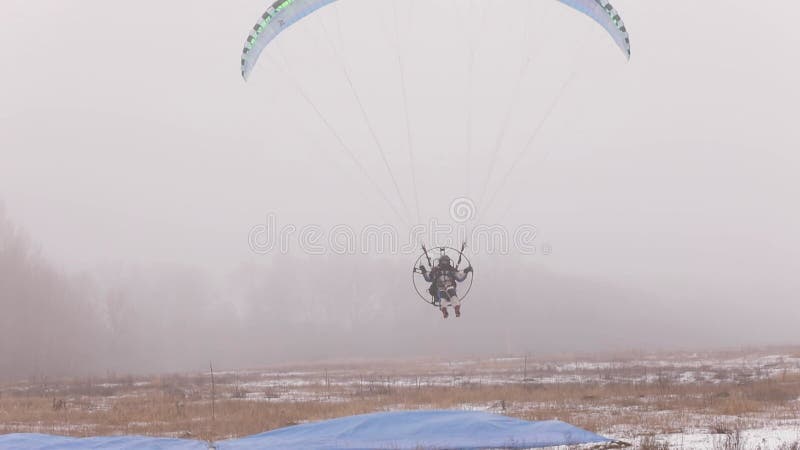 Atterraggio con parapotore parapendista che brilla nella nebbia