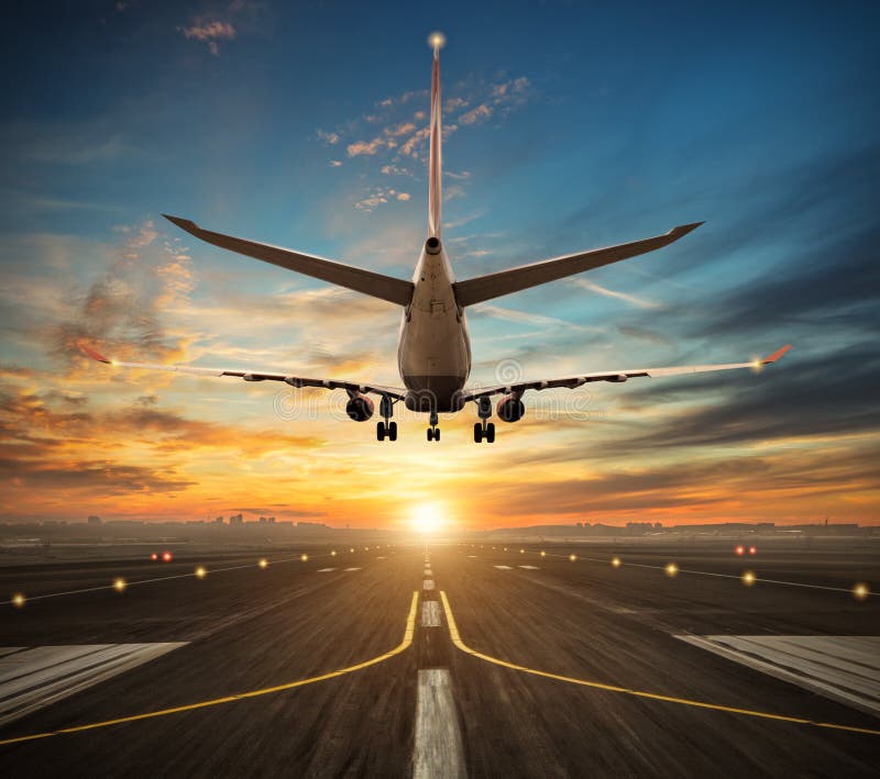 Atterrissage d'avion à la piste d'aéroport dans la lumière de coucher du soleil