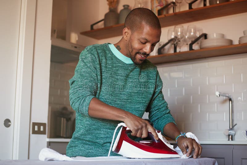 Attractive American Black Man is Ironing White Shirt at Home Stock ...