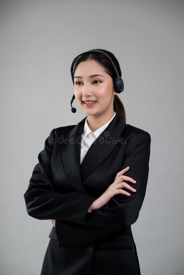 Attractive Asian operator with formal suit and headset. Enthusiastic royalty free stock photography