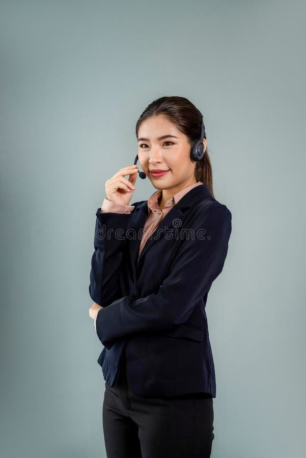 Attractive Asian operator with formal suit and headset. Enthusiastic stock image